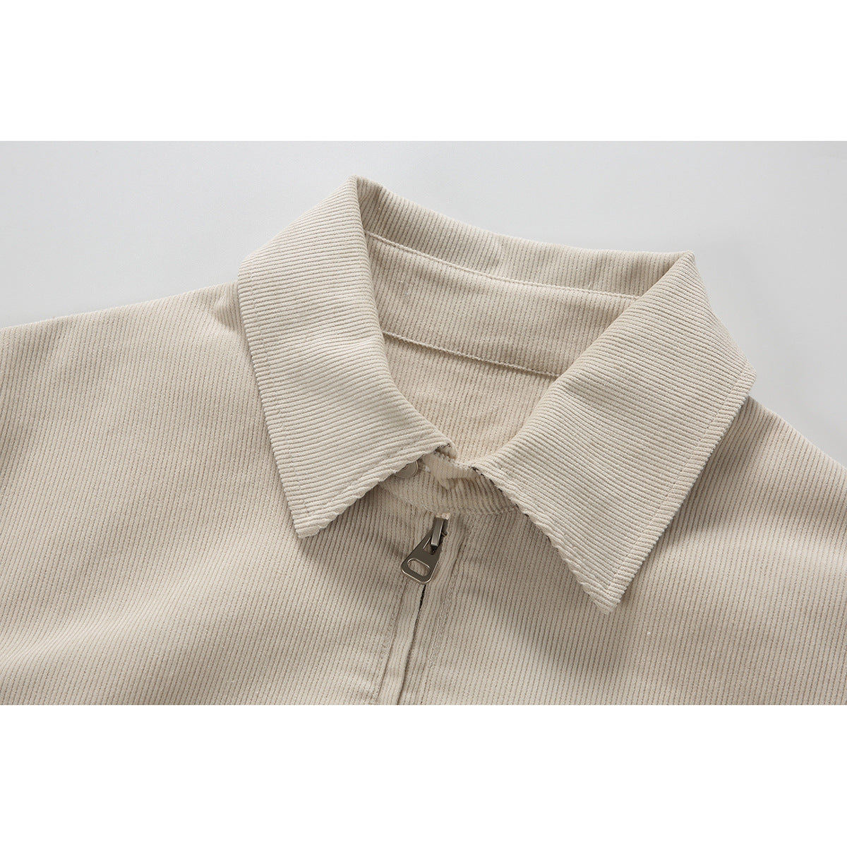 Close-up of a light beige ribbed jacket collar and front zipper.