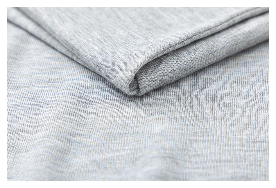 Close-up of folded light gray heather knit fabric showing its texture and edge.