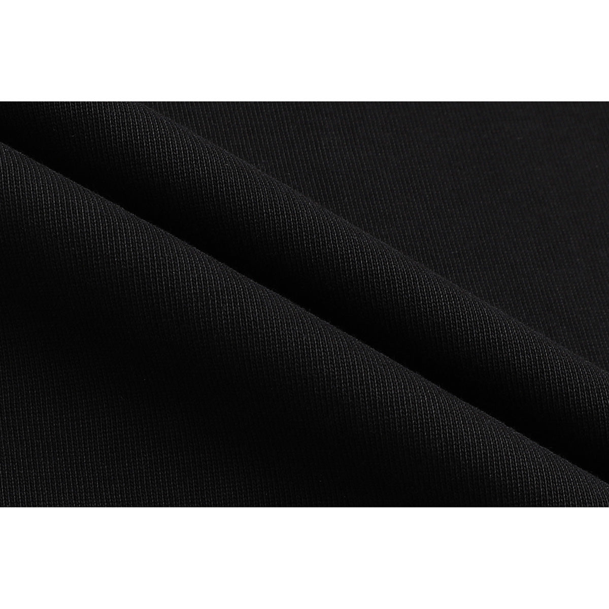 Extreme close-up of black fabric folded to show its surface texture.