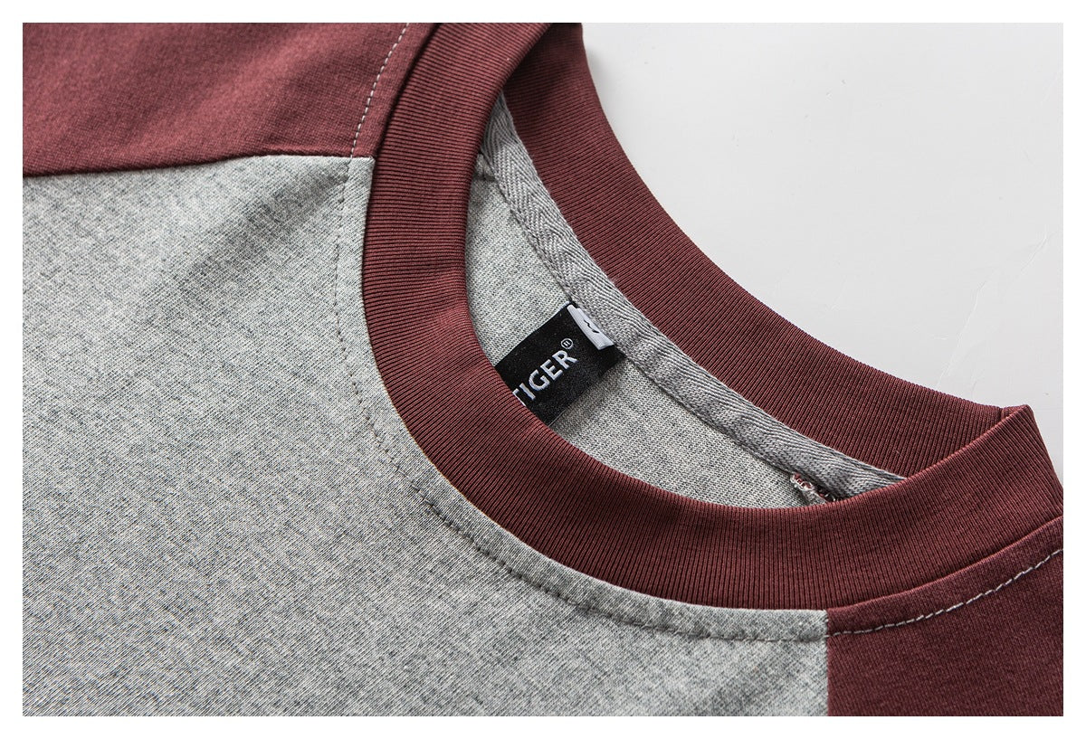 Close-up of a burgundy ribbed crew neckline on a heather-gray top, with the inside neck label visible.