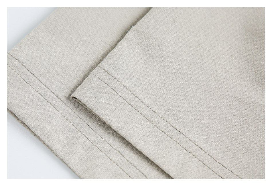 Close-up of a light beige garment hem with parallel rows of stitching.