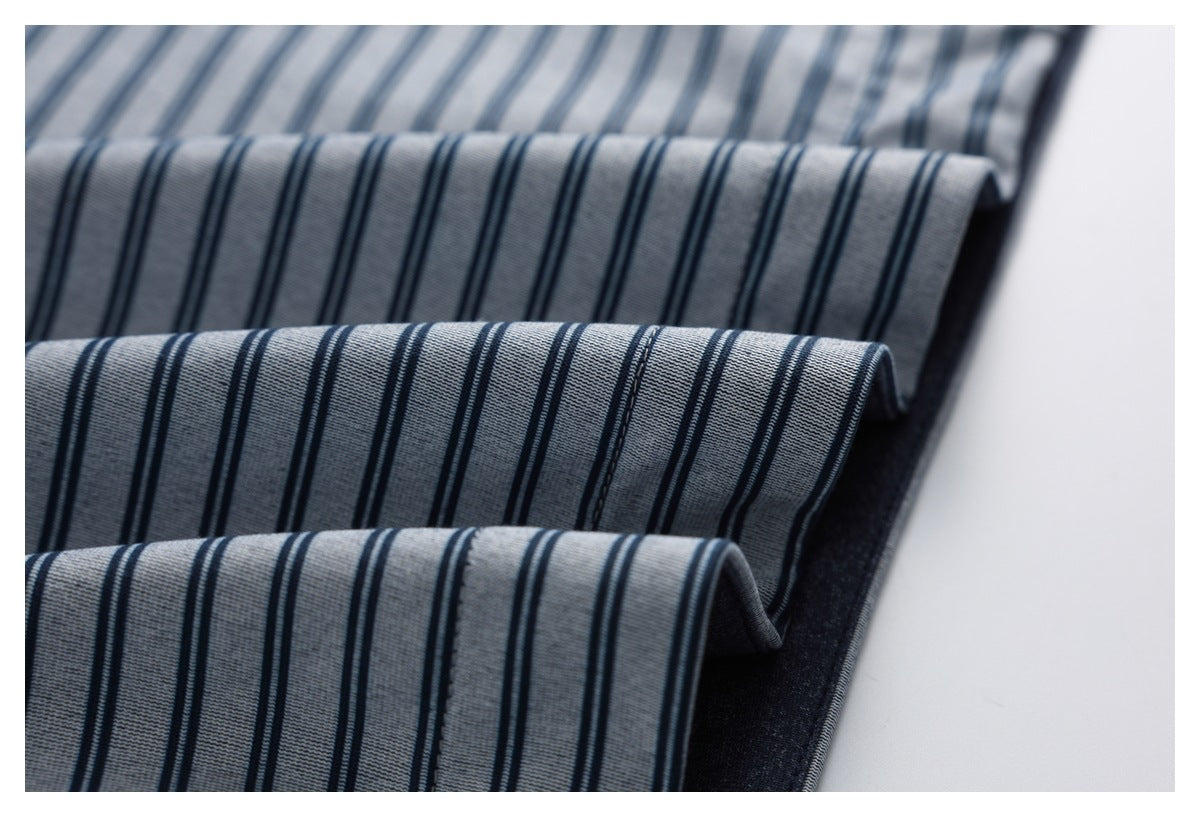 Close-up of the gray-blue striped fabric folded into layers, showing the dark reverse and stitched edges.