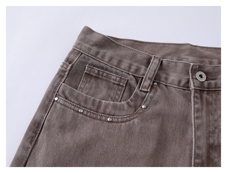 Close-up of the taupe jeans’ front pocket, coin pocket, waistband and metal rivets.
