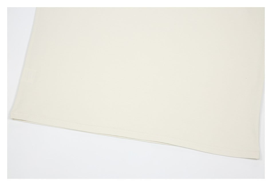 Close-up of the plain ivory sweatshirt hem and stitching.