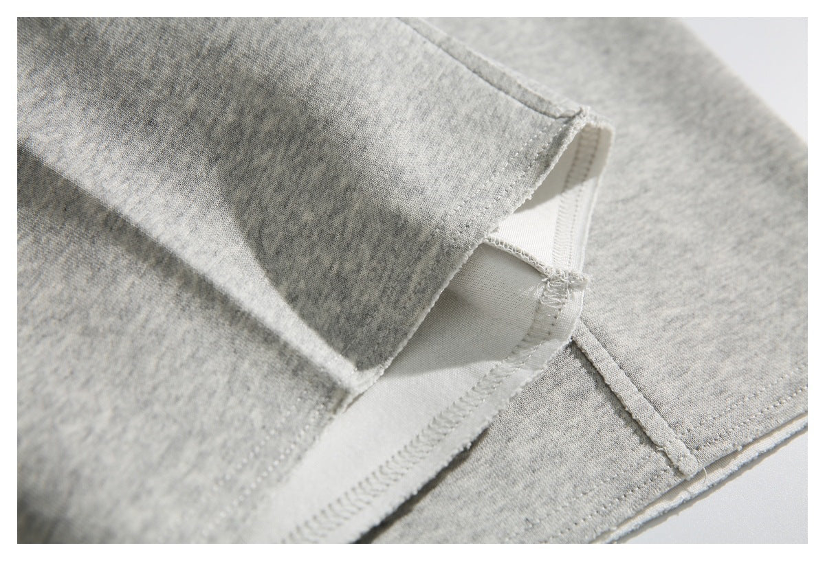 Close-up of gray heather shorts showing an inner seam and stitched hem.