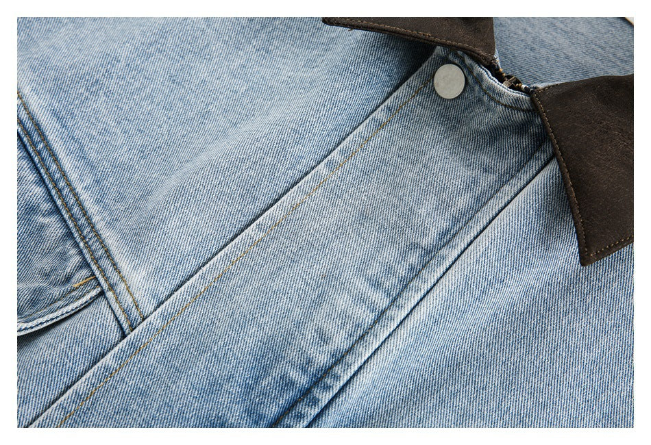 Close-up of the light blue denim jacket's stitching, front placket and metal snap.
