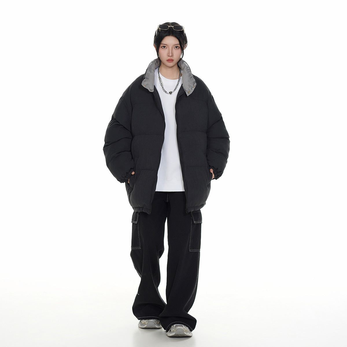 Model wearing a black oversized quilted puffer jacket with a gray-lined collar, shown from the front.