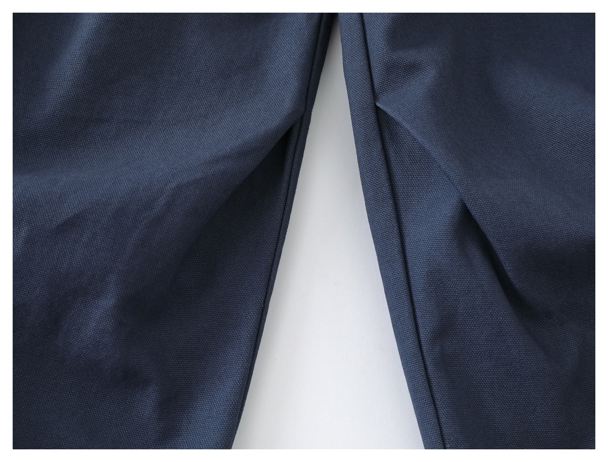 Close-up of blue trouser legs and the inner seam against a white background.