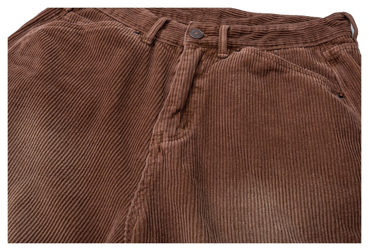 Close-up of brown corduroy trousers showing the waistband, button, belt loops, fly, and front pockets.