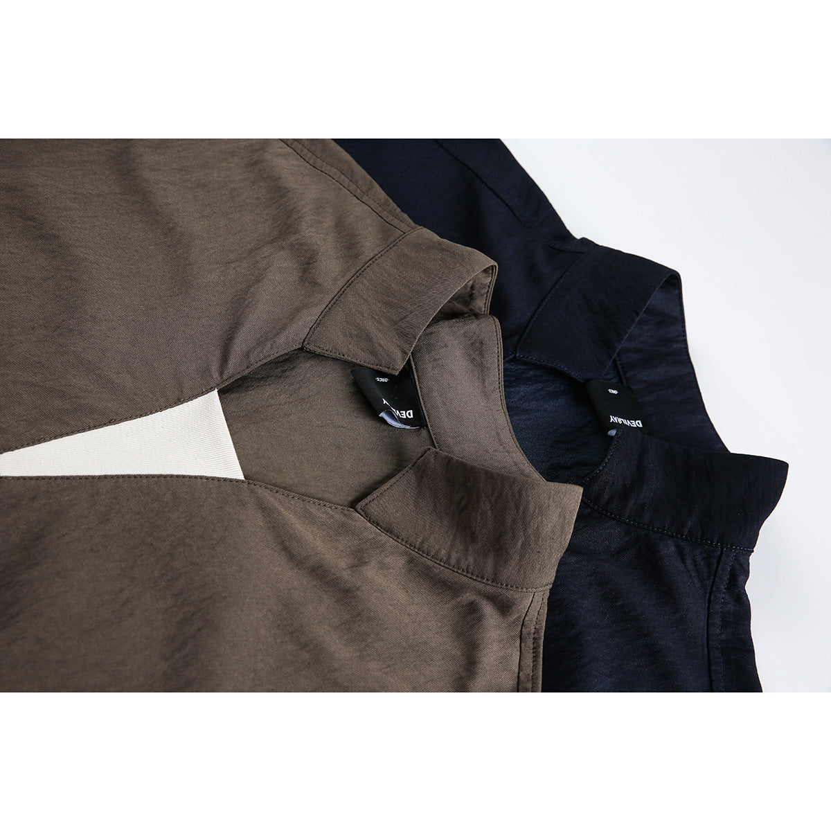 Close-up of brown and navy short-sleeve tops showing their stand collars and split necklines.