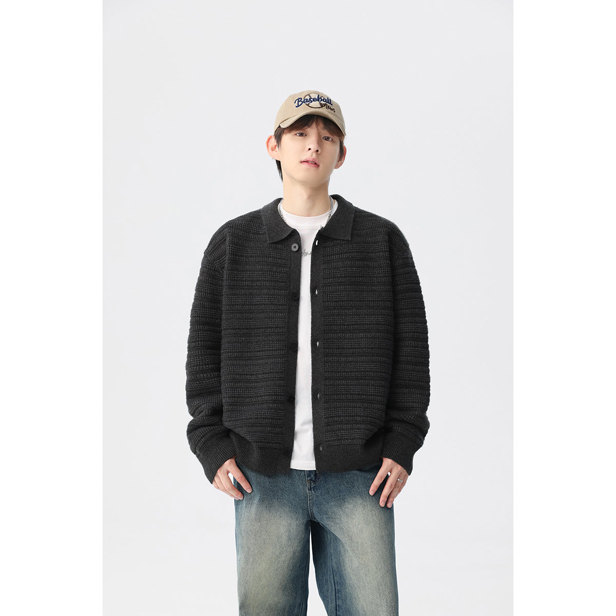 Model wearing a dark charcoal textured knit cardigan with a collar and button front over a white shirt.