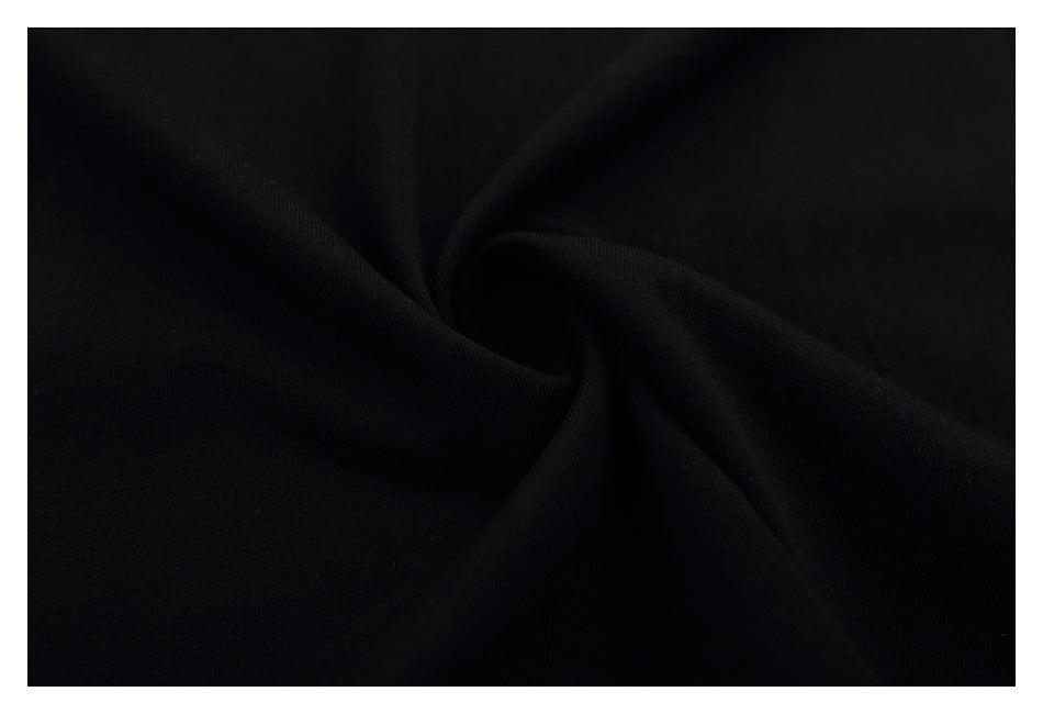 Close-up of black T-shirt fabric gathered into a soft spiral fold.