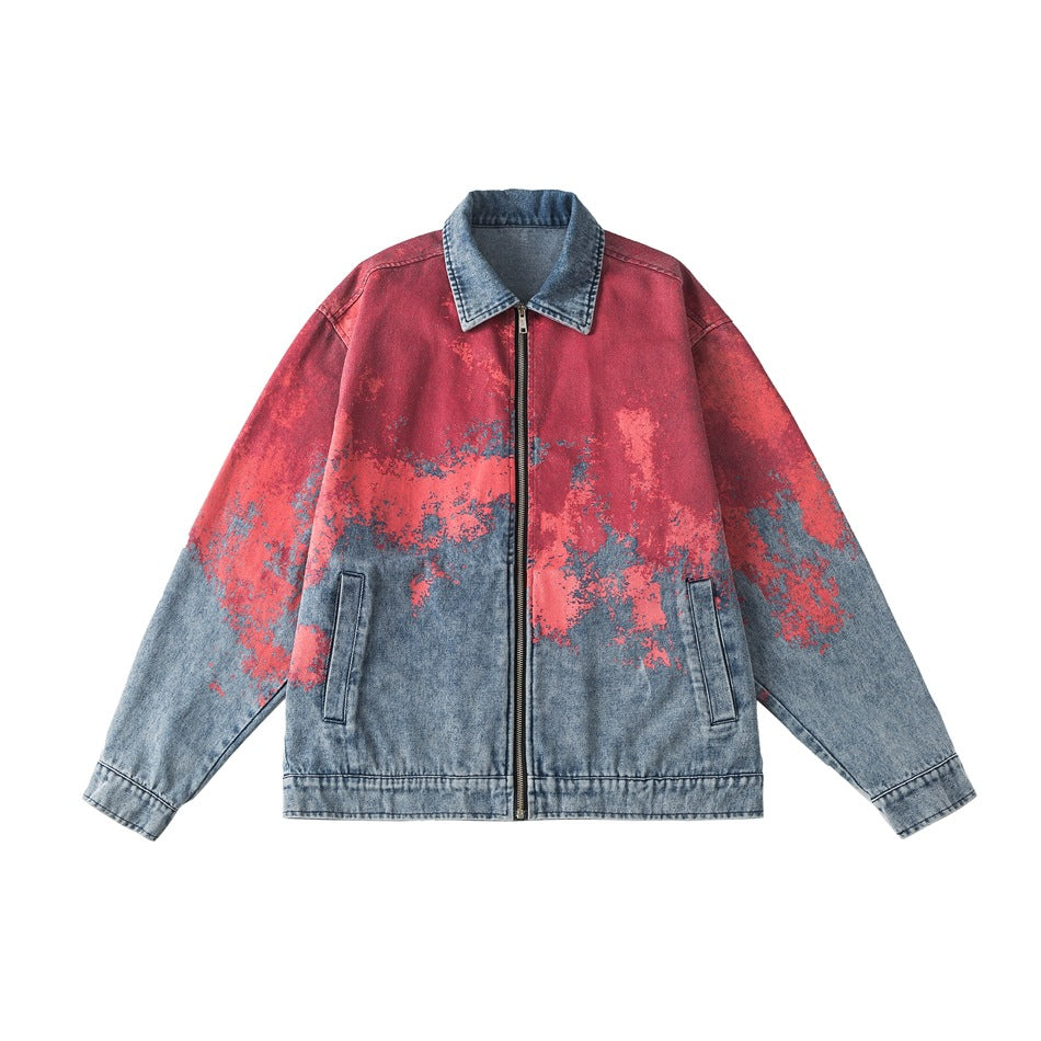 Blue washed denim zip jacket with red and pink splatter print on the upper body and sleeves, flat front view