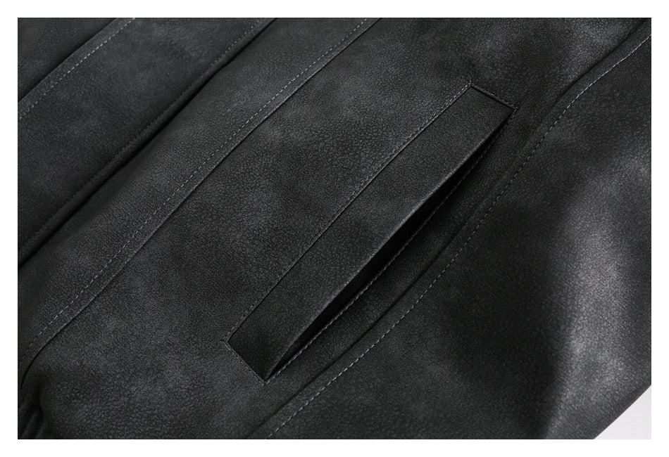 Close-up of a dark jacket showing a narrow welt pocket and stitched panel seams.