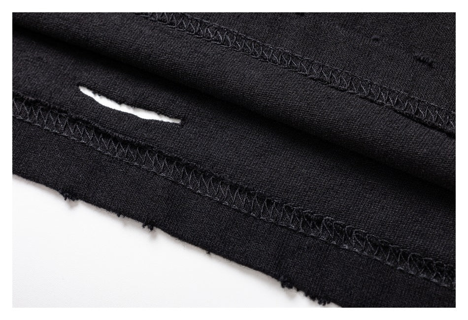 Close-up of black garment seams and a narrow distressed tear.