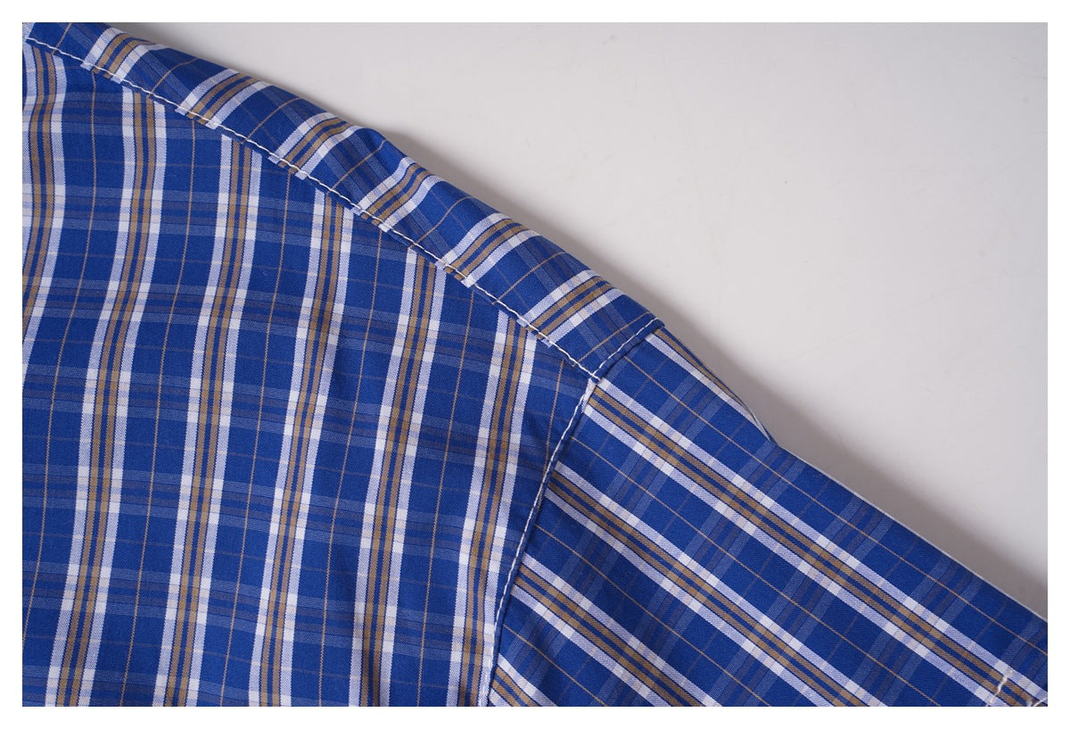 Close-up of the blue plaid shirt's shoulder seam and sleeve attachment.
