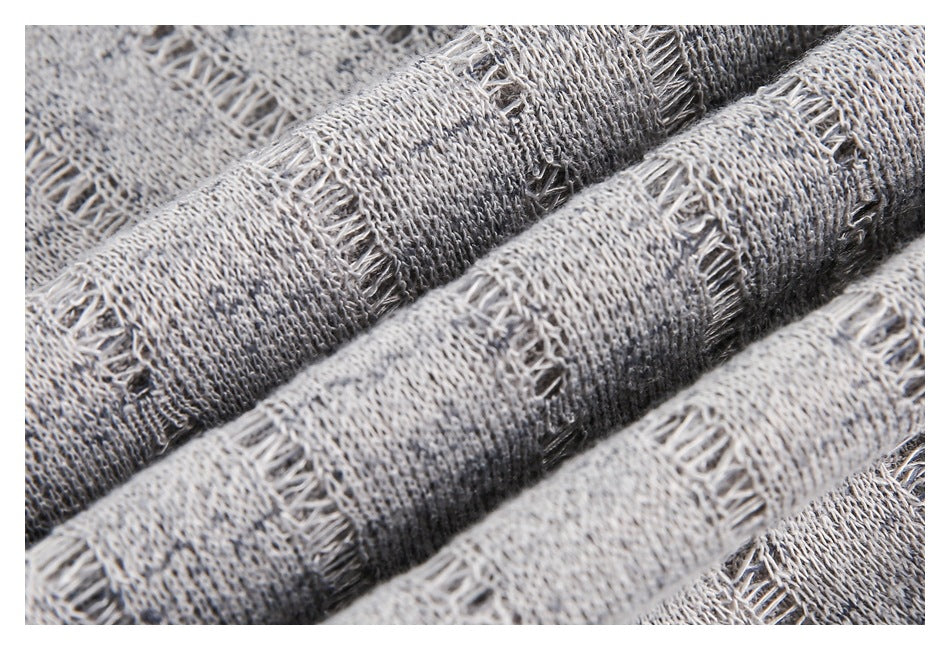 Macro view of gray fabric with raised woven bands and open stitch details.