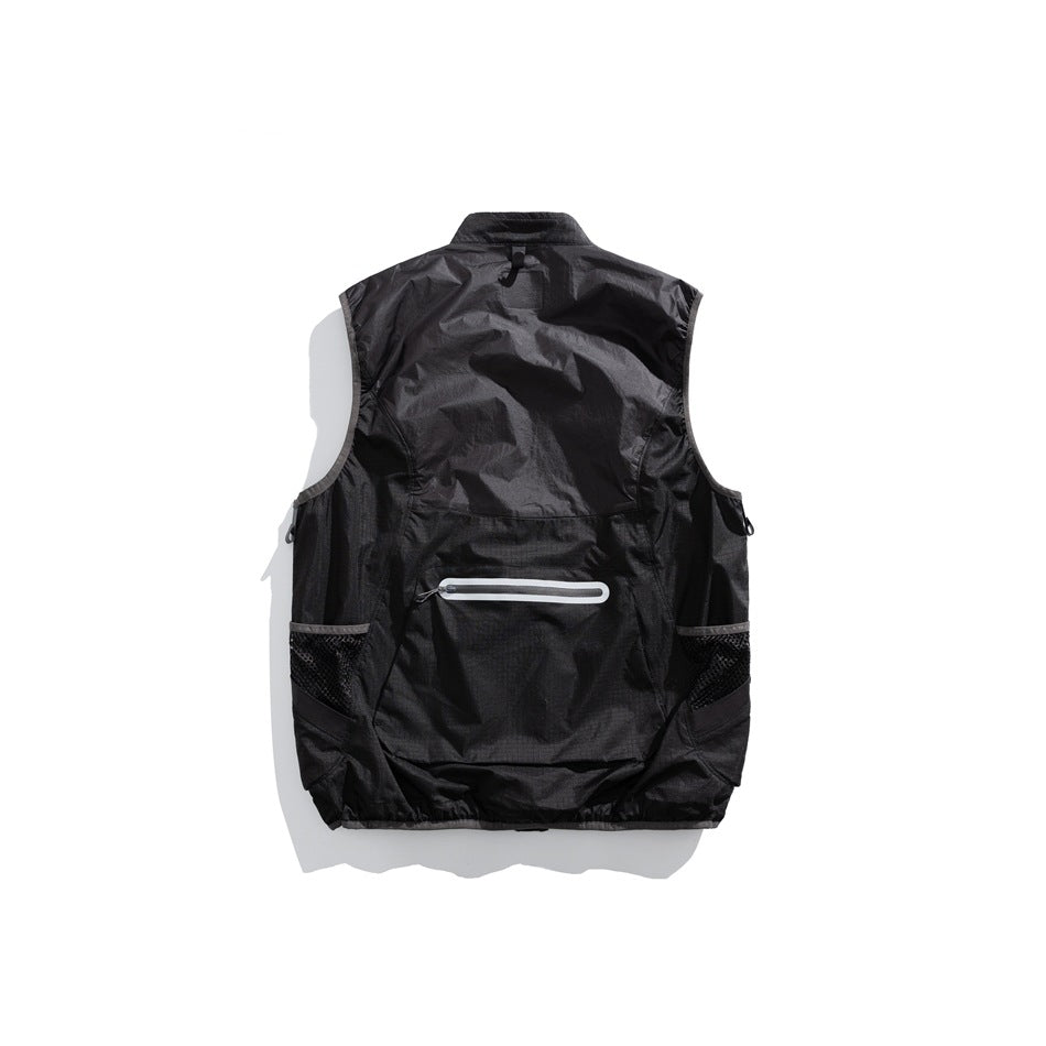 Back view of a black sleeveless utility vest with mesh side pockets and a horizontal rear zipper.