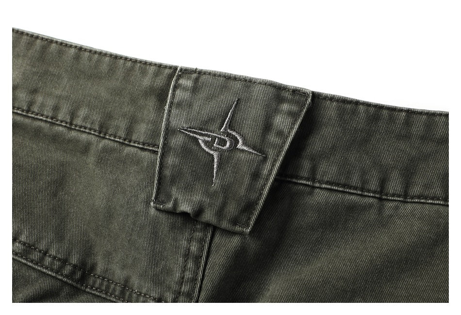 Close-up of the pants' waistband and small embroidered emblem on a center belt loop.