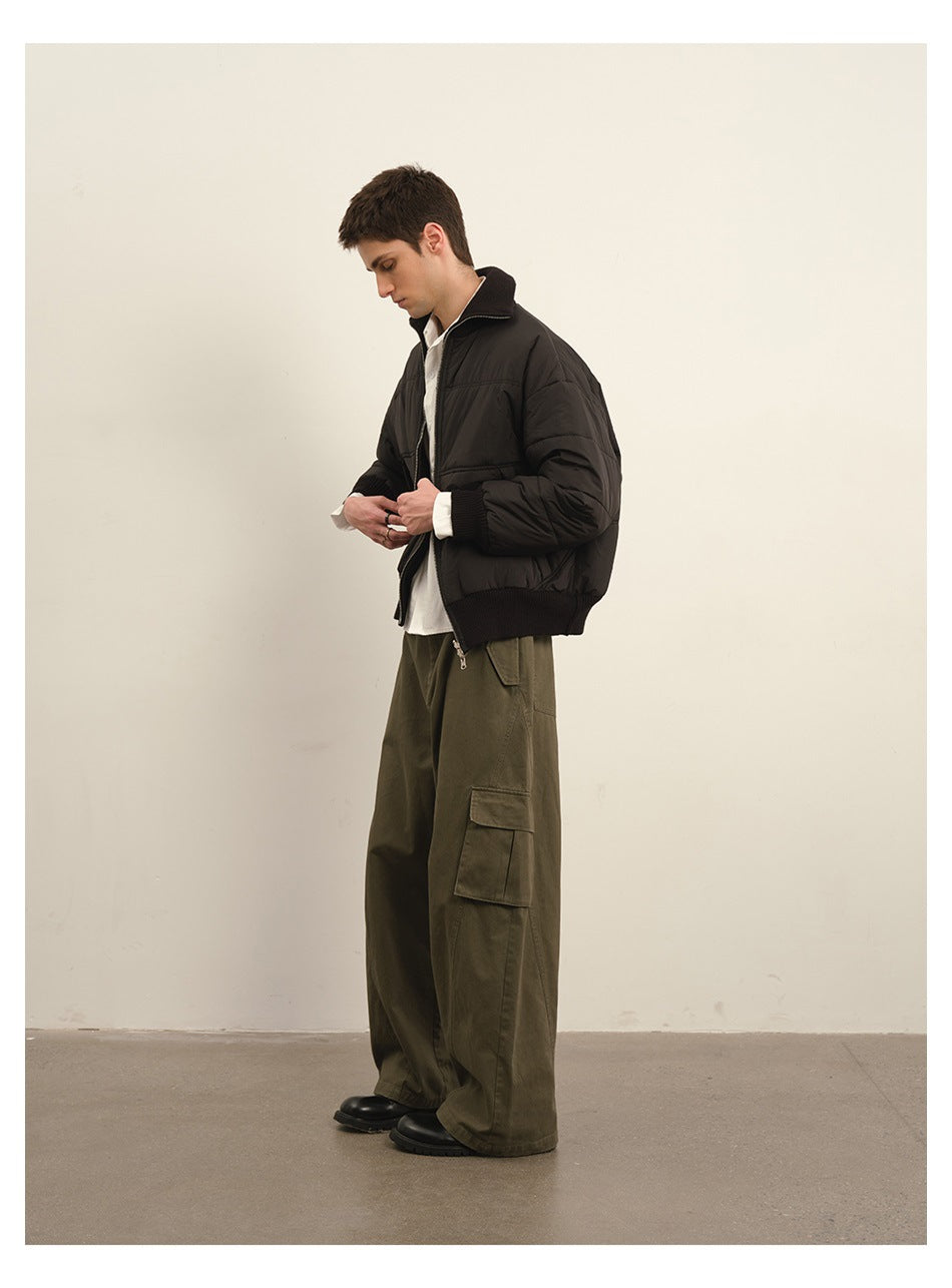 Model in olive wide-leg cargo pants with side flap pocket, black jacket and boots, side profile
