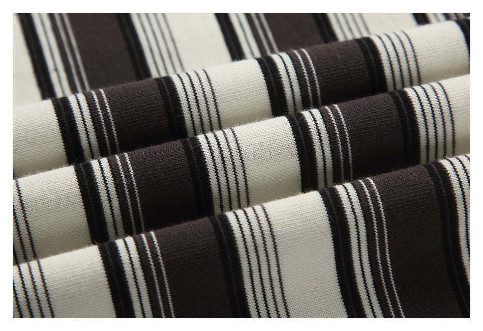 Close-up of folded cream and dark brown striped knit fabric showing its alternating stripe pattern.
