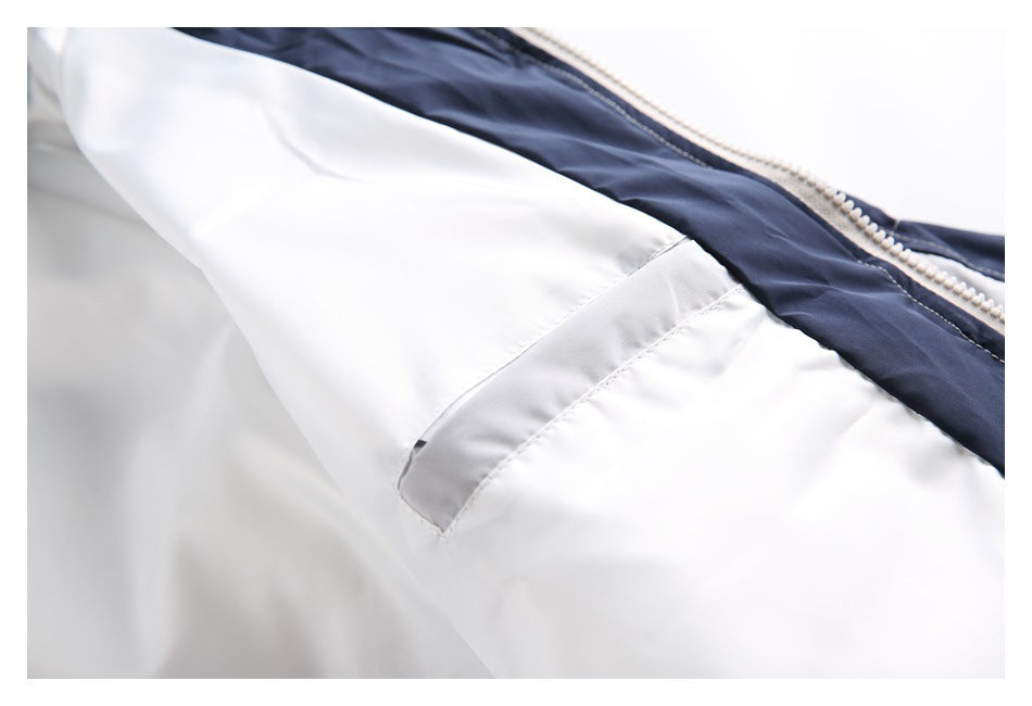 Close-up of the jacket's zipper, navy inner trim, and light gray panel seam.