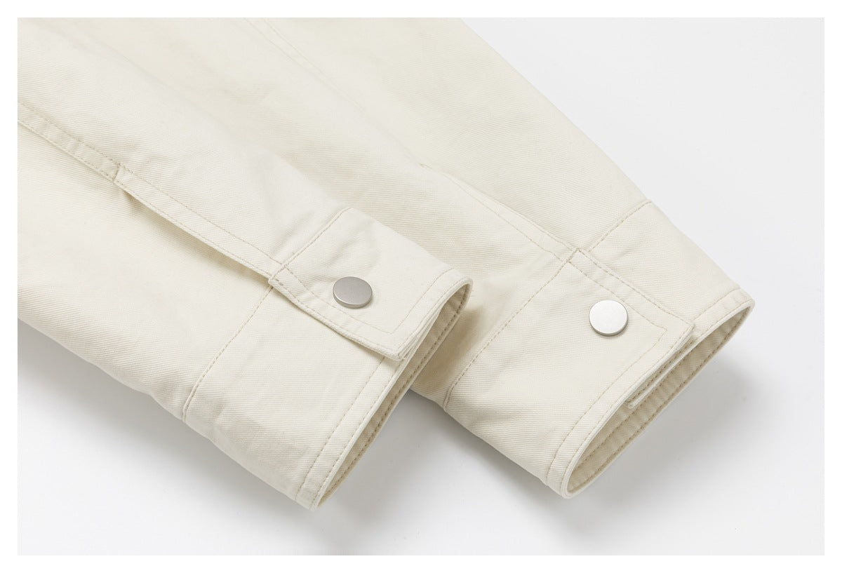 Close-up of two ivory sleeves with snap-button cuffs and stitched seams.