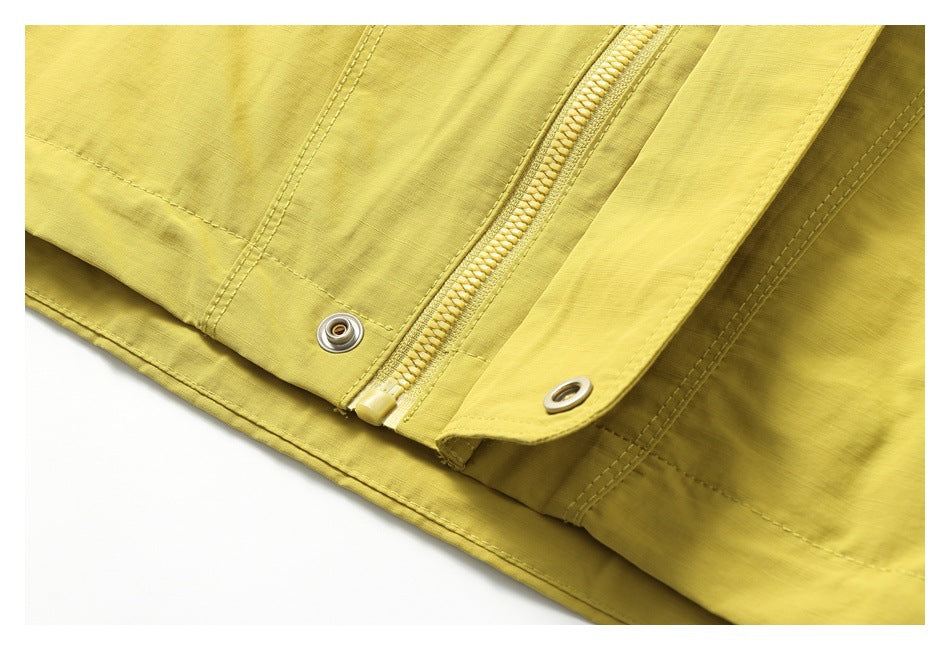 Close-up of the mustard-yellow jacket's zipper placket and metal snap fasteners.