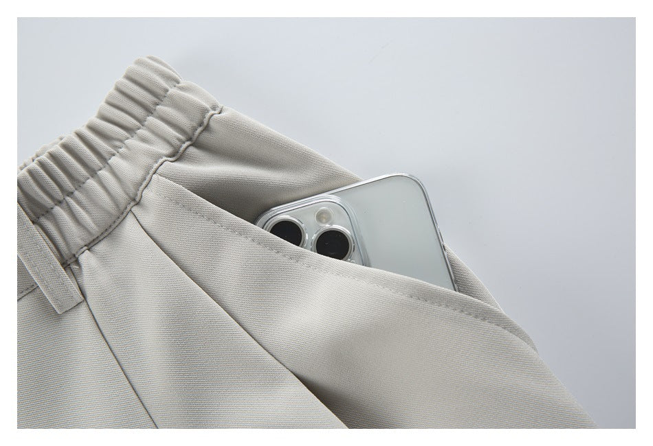 Close-up of a deep pocket on light beige trousers holding a smartphone.