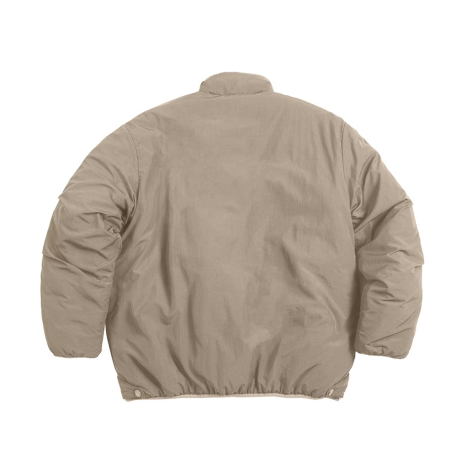 Back view of a beige jacket with a high collar, rounded sleeves, and snap-adjustable hem.