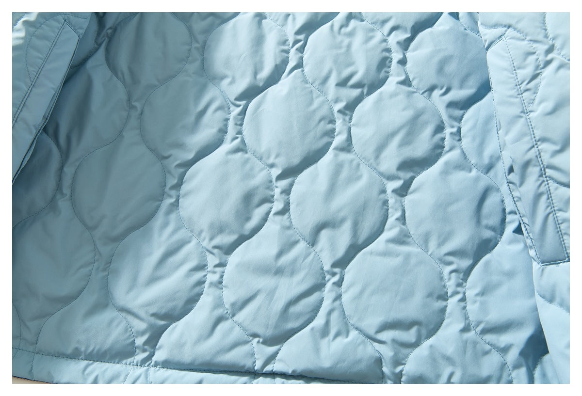 Close-up of the light blue jacket lining with large rounded quilted stitching and a seam.