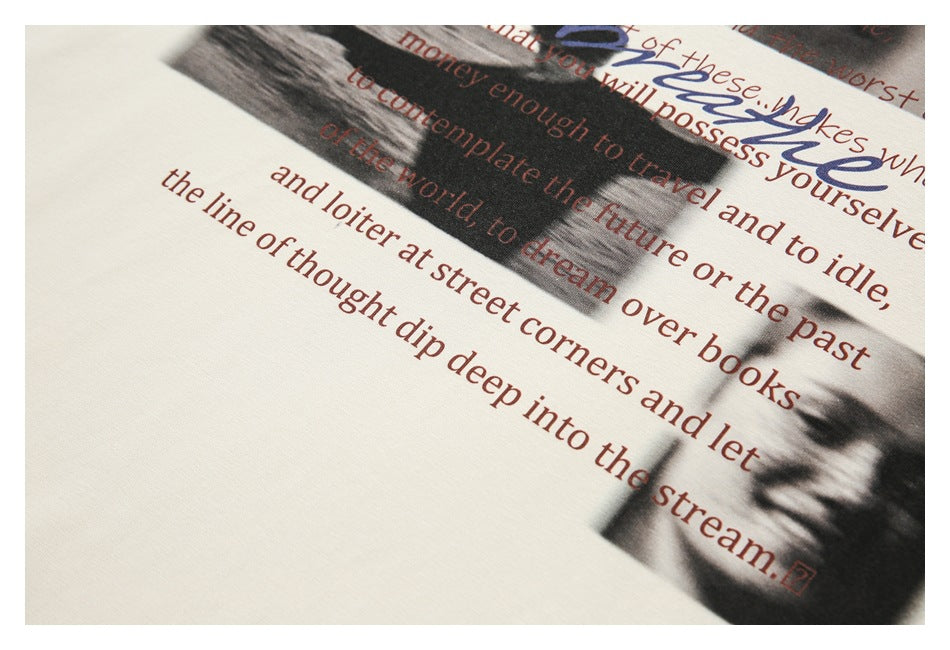 Close-up of a cream T-shirt print with grayscale portraits and dark red English lettering.