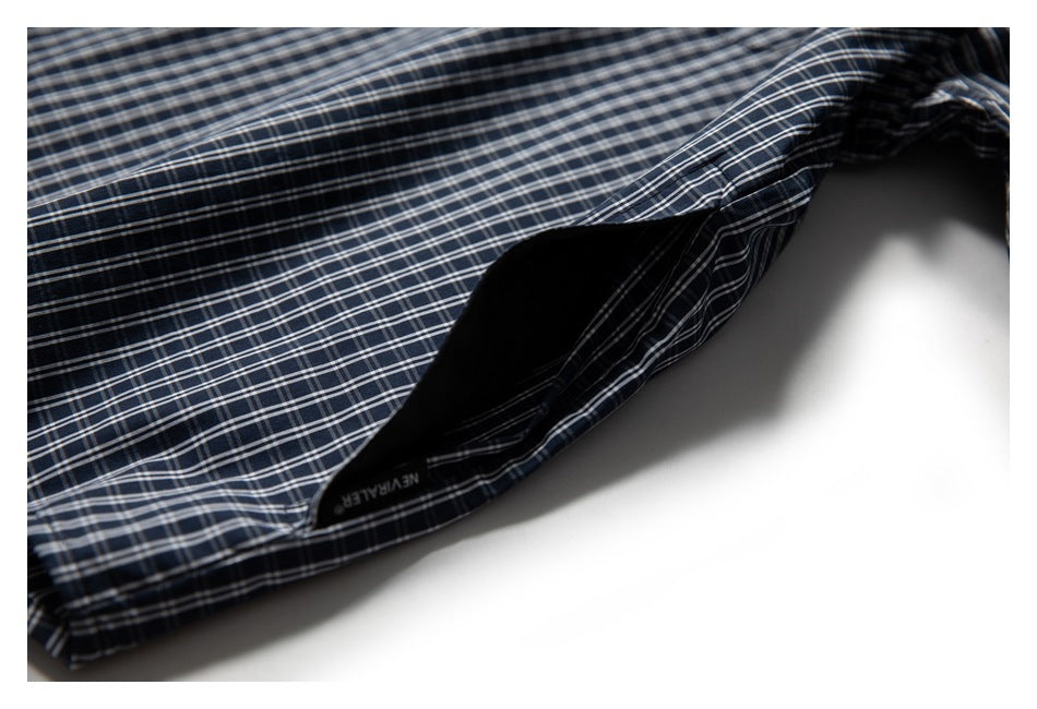 Close-up of the navy plaid shirt hem, with an interior label visible.