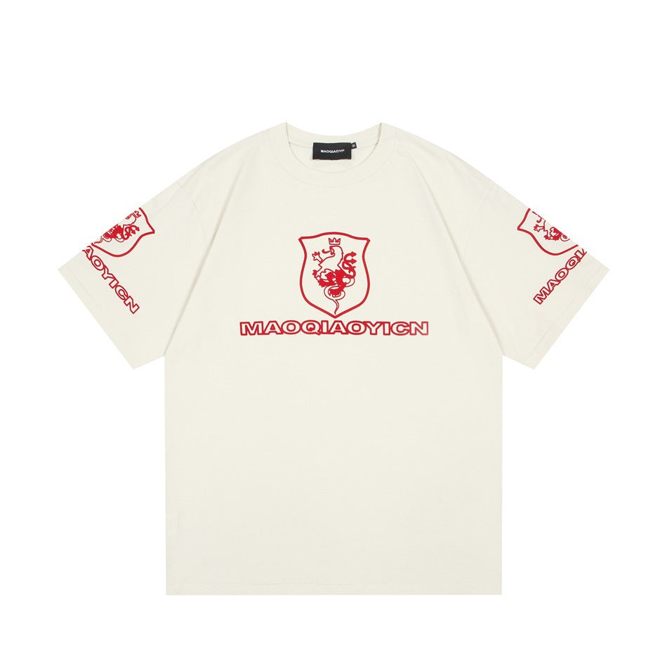 Apricot cream short-sleeve crew-neck t-shirt with red lion shield crest and lettering on chest and sleeves, flat lay front