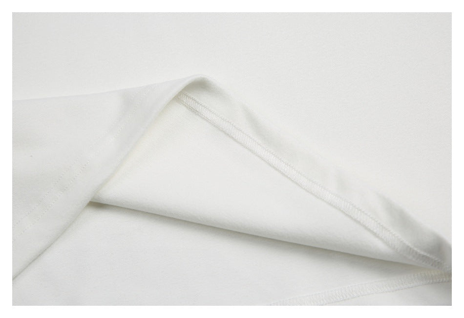 Close-up of white garment fabric folded back to show an overlocked seam.