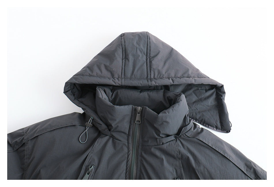 Close-up of a charcoal gray jacket front with a large hood draped over its high collar and center zipper.