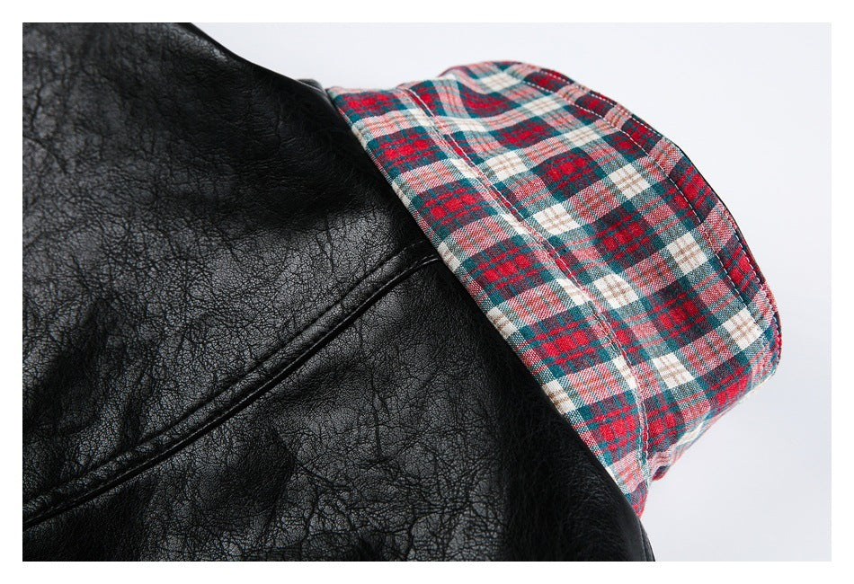 Close-up of black jacket material beside a red, teal, and cream plaid cuff.