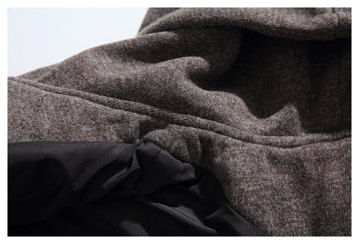 Close-up of mottled dark brown fabric meeting smooth black lining along a stitched seam.