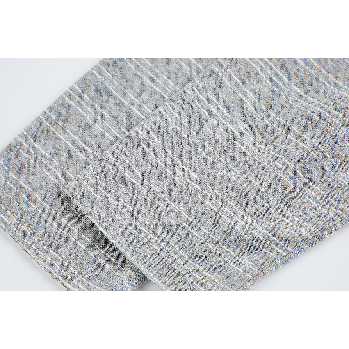 Close-up of folded heather gray fabric with thin white stripes and stitched edges.
