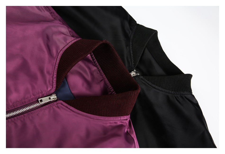 Close-up of plum and black bomber jackets showing ribbed collars and front zipper details.