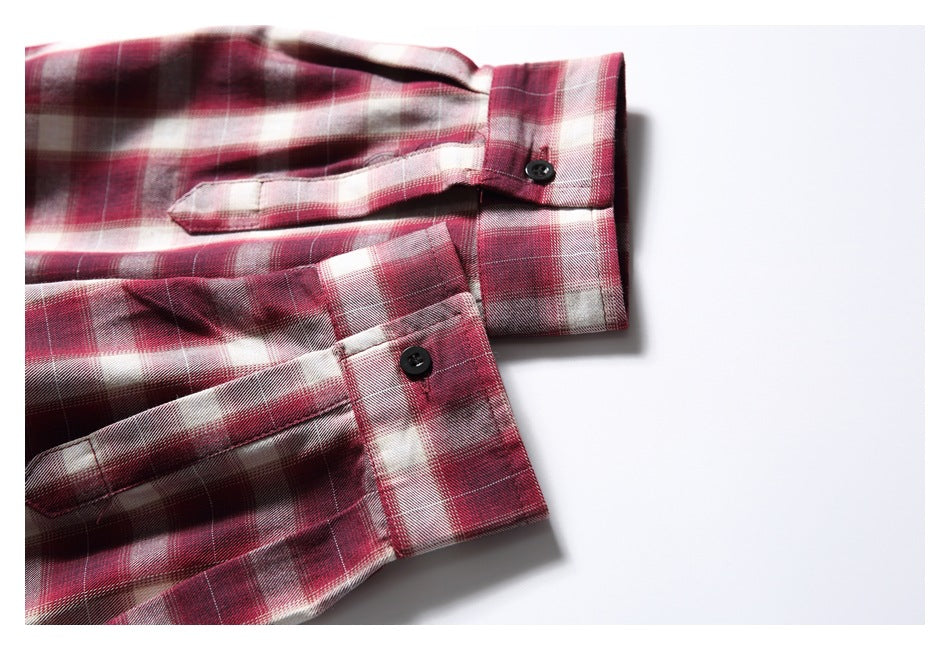 Close-up of the plaid shirt's buttoned cuffs and sleeve plackets against a white background.