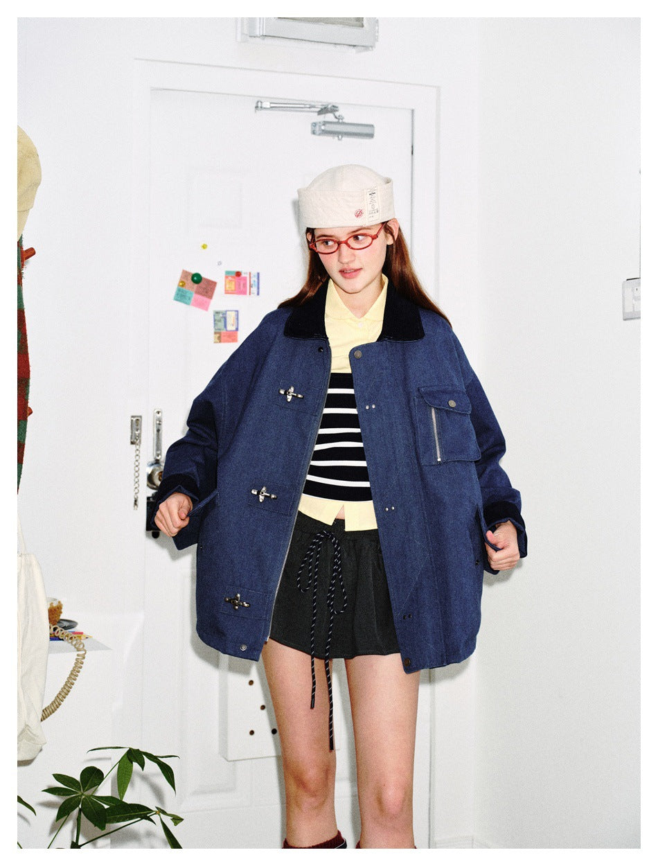 Model wearing an open navy jacket with toggle closures and chest pocket over a striped top, with cap and red glasses