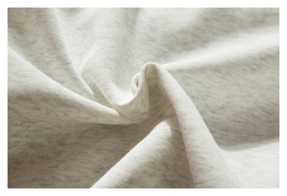Close-up of pale gray marled fabric gathered into soft folds.