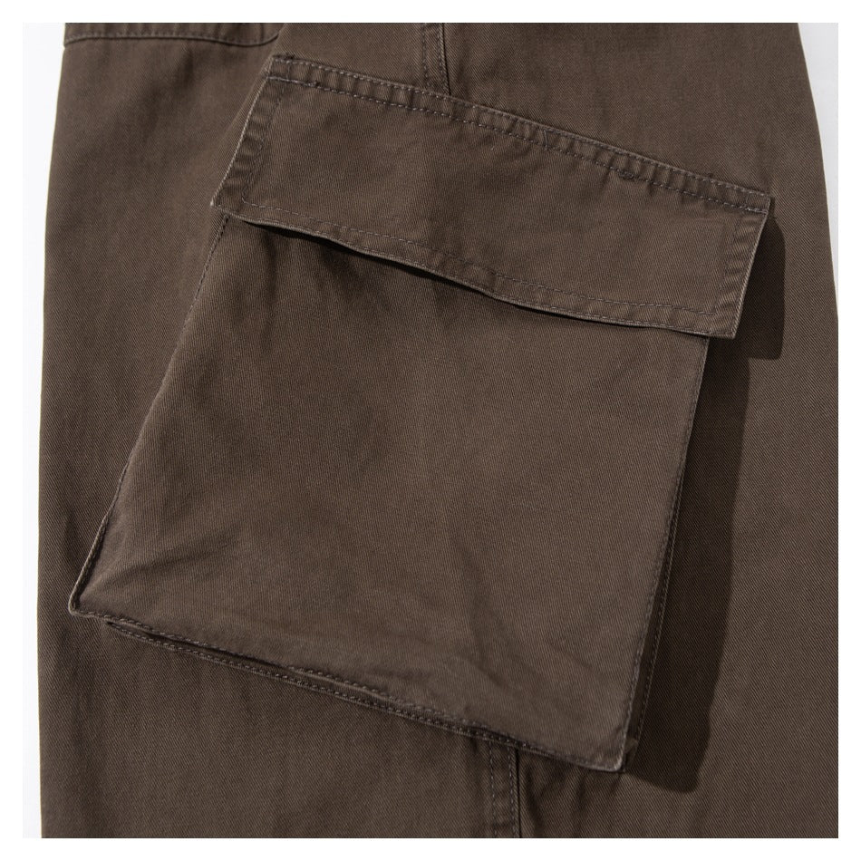Close-up of a large flap cargo pocket on dark brown trousers.