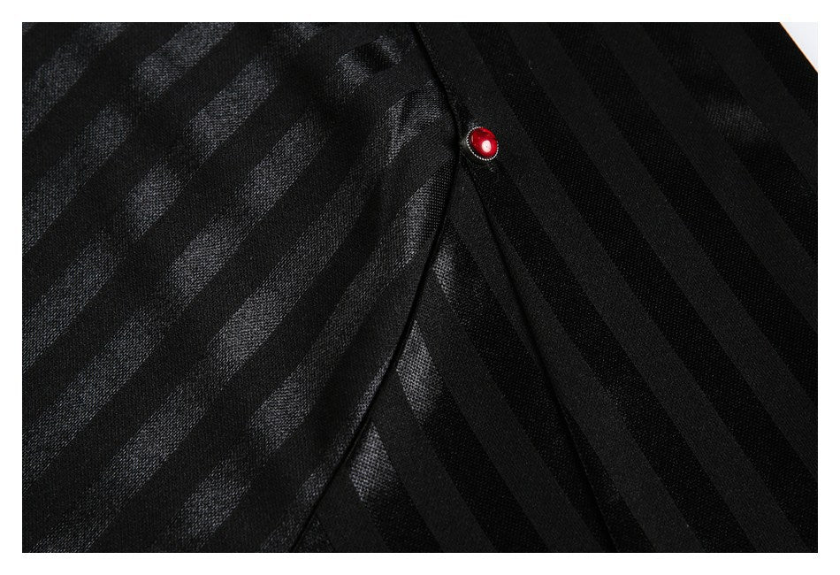 Close-up of black fabric with diagonal tonal stripes and a small red button.