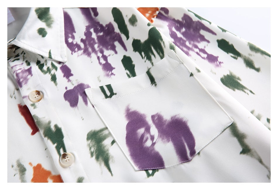 Close-up of the shirt's pointed chest pocket, buttons, and purple, green, and orange print.