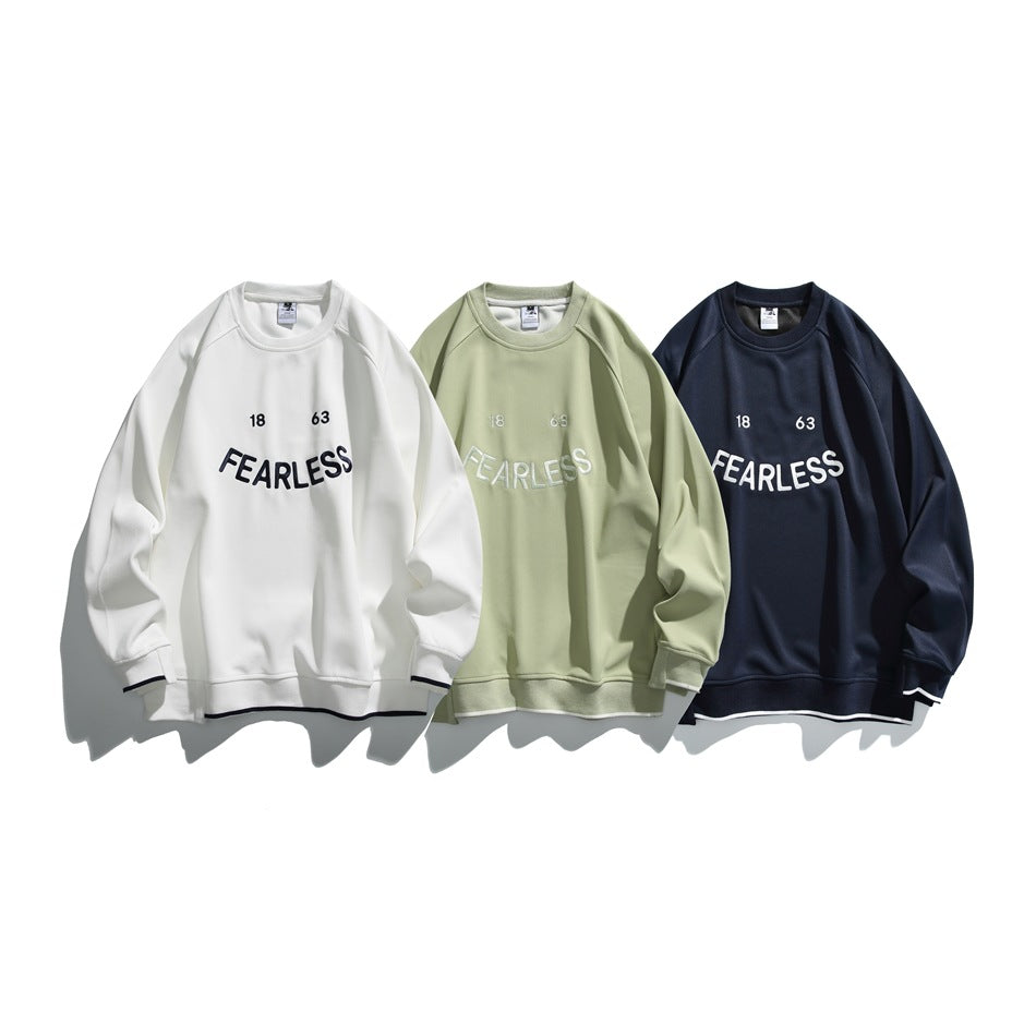 Three crewneck sweatshirts displayed together in white, sage green, and navy, each with FEARLESS lettering.