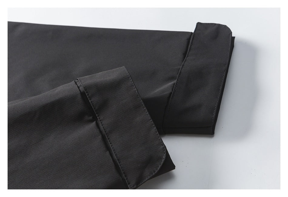 Close-up of two black jacket sleeve cuffs with wide fabric closures.