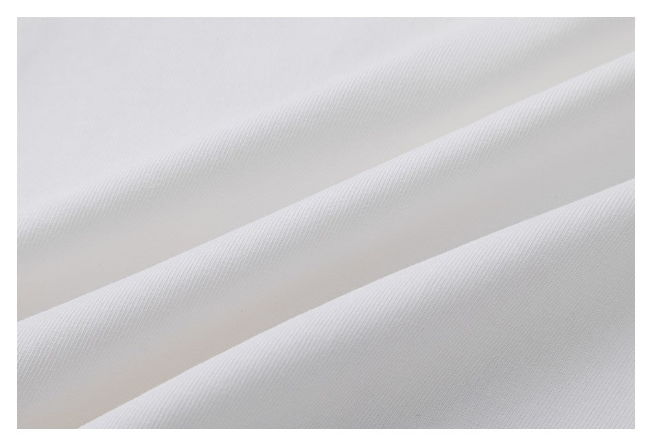 Close-up showing the fine surface texture of white T-shirt fabric arranged in soft folds.