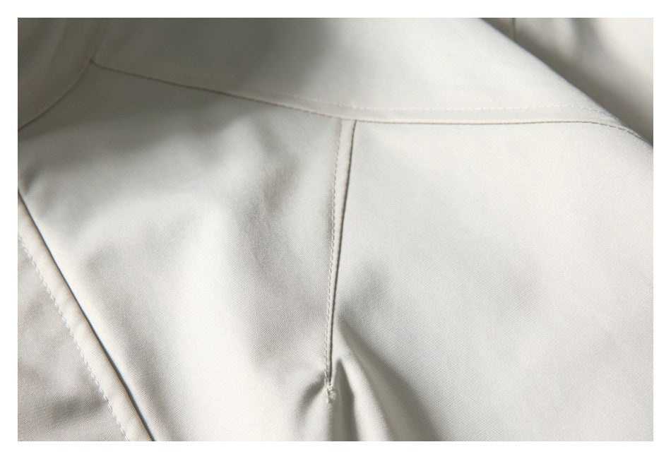 Close-up of the ivory jacket's stitched shoulder and panel seams.